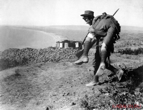 солдат выносит с поля боя раненного товарища